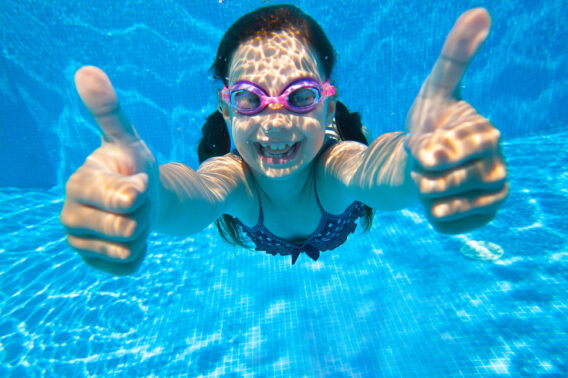 Young girl under water big smile into camera with thumbs up for Contact Performance Solar