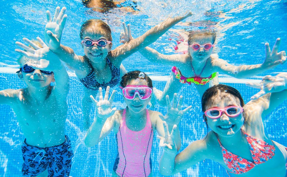 Children under water smiling into the camera